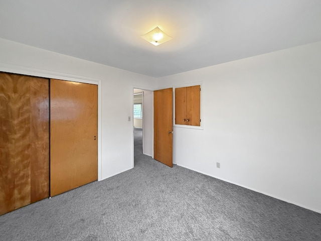 unfurnished bedroom with carpet flooring, baseboards, and a closet