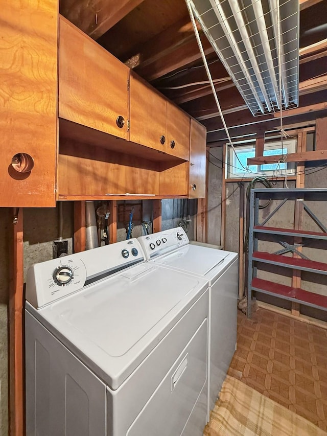 washroom featuring cabinet space, separate washer and dryer, and light floors