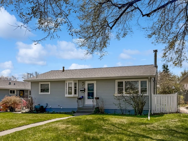 ranch-style home featuring fence and a front yard