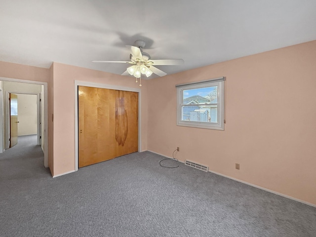 unfurnished bedroom featuring a ceiling fan, visible vents, carpet, and a closet