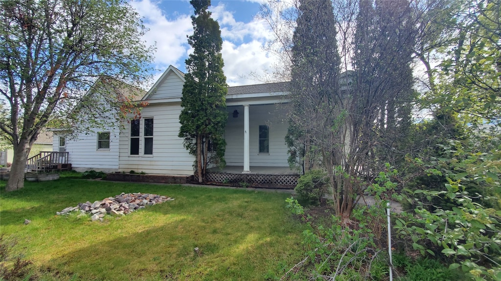 rear view of property with a porch and a yard