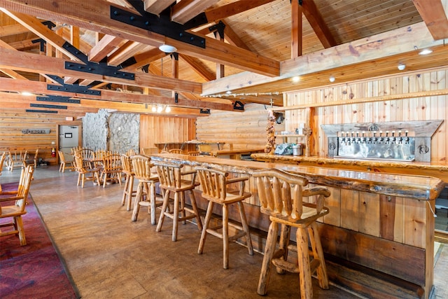 bar with a community bar, beamed ceiling, wooden ceiling, and high vaulted ceiling