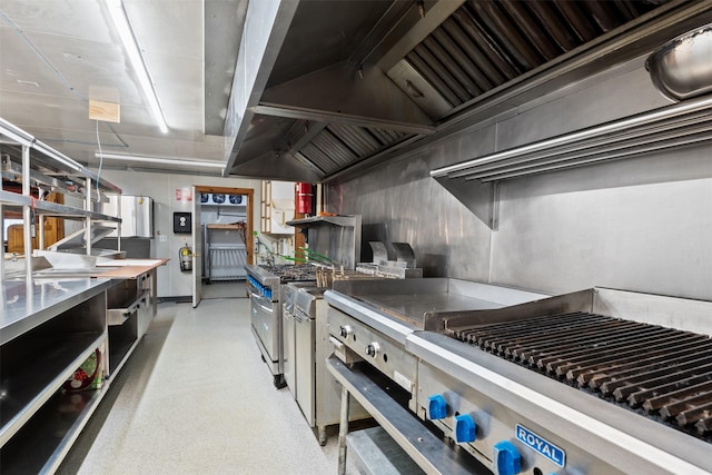 kitchen featuring stainless steel counters, custom exhaust hood, and range with two ovens