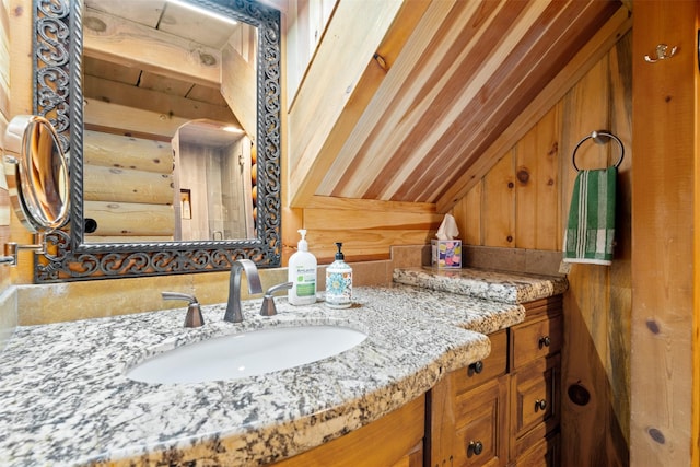 bathroom featuring vanity and lofted ceiling