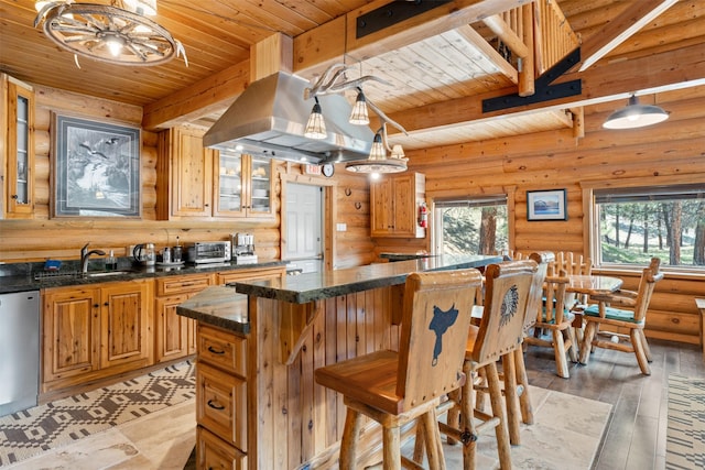 kitchen with wood ceiling, a center island, a sink, rustic walls, and beamed ceiling