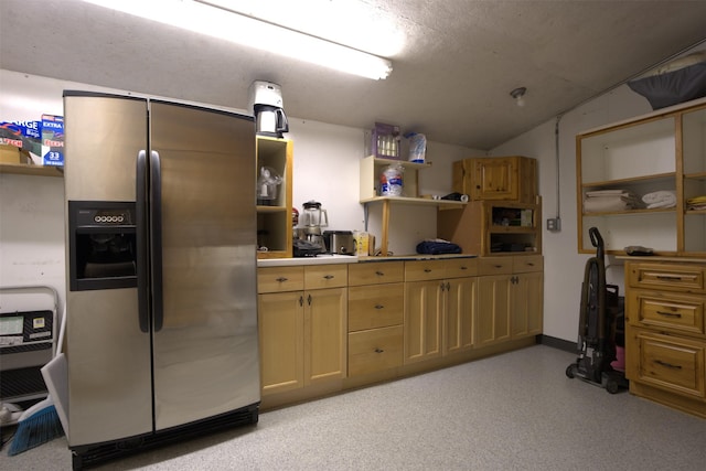 kitchen featuring stainless steel fridge, light countertops, open shelves, and vaulted ceiling