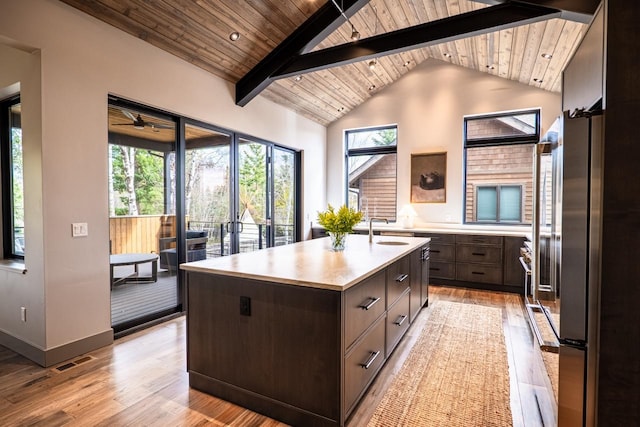 kitchen with light countertops, wood ceiling, a wealth of natural light, and dark brown cabinets