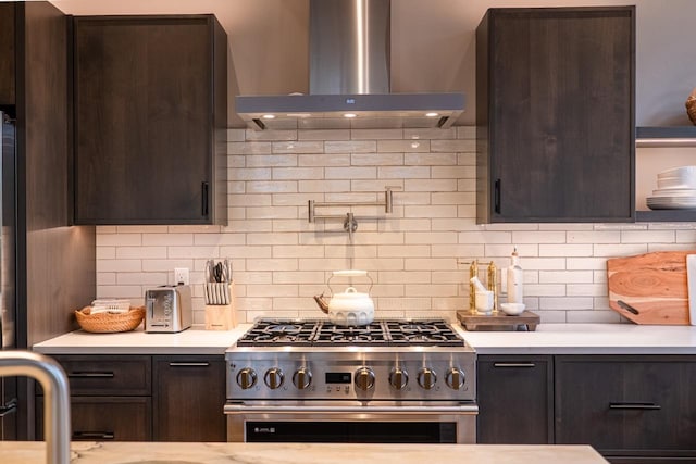kitchen featuring light countertops, dark brown cabinetry, ventilation hood, and stainless steel stove