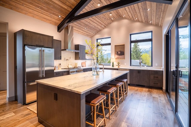 kitchen featuring wall chimney range hood, wood ceiling, light wood finished floors, and high end refrigerator