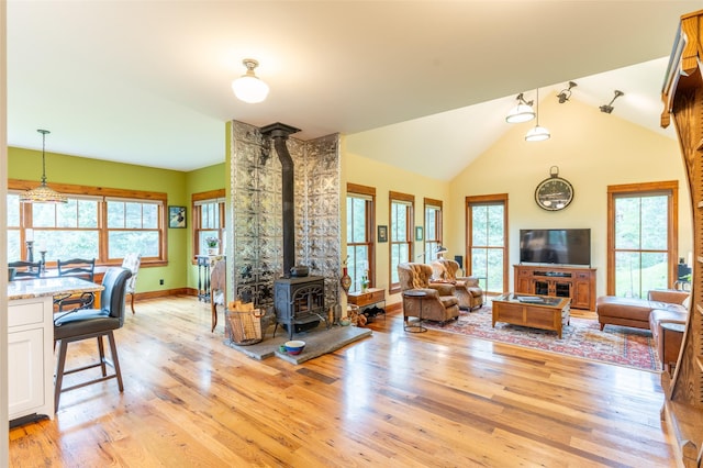 6710 Farm To Market Rd, Whitefish, MT 59937 - living room with a wood stove, light wood-style flooring, plenty of natural light, and lofted ceiling