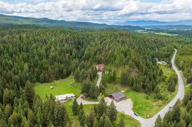 birds eye view of property featuring a mountain view and a wooded view