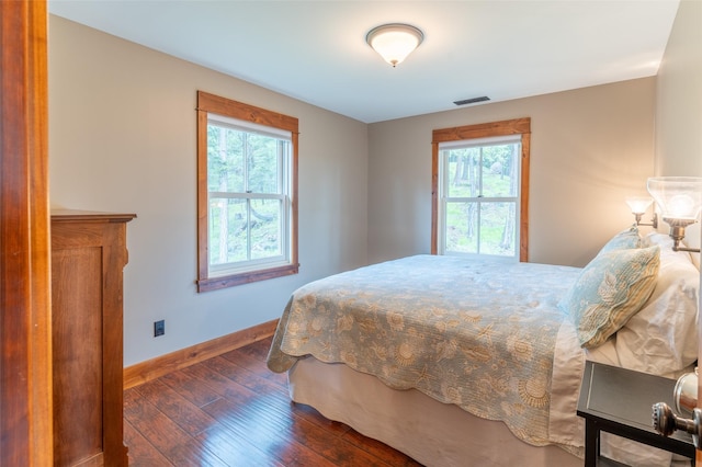 bedroom featuring baseboards, multiple windows, dark wood-style floors, and visible vents