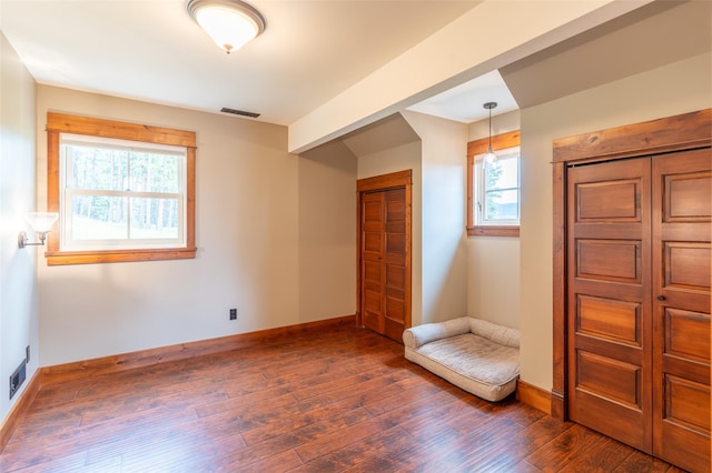 interior space featuring baseboards and dark wood-type flooring