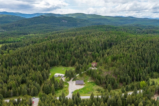 birds eye view of property featuring a wooded view and a mountain view