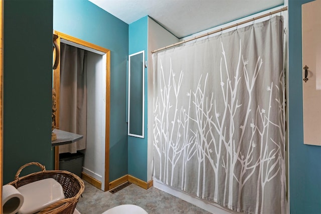bathroom featuring baseboards, concrete floors, and curtained shower