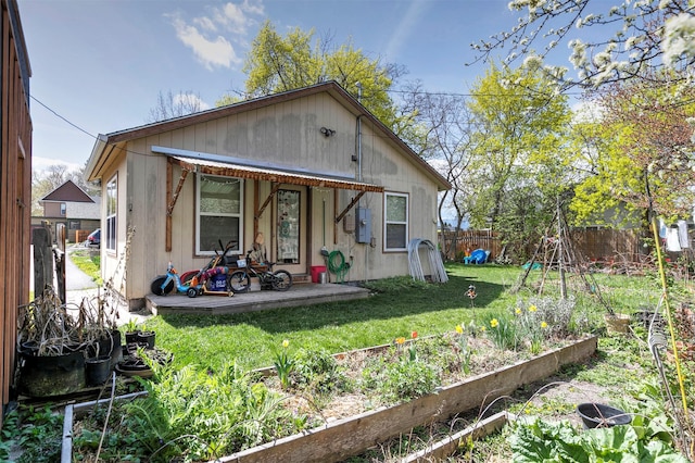 rear view of house featuring a fenced backyard, a garden, a patio area, and a yard
