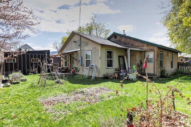 back of house featuring fence and a yard