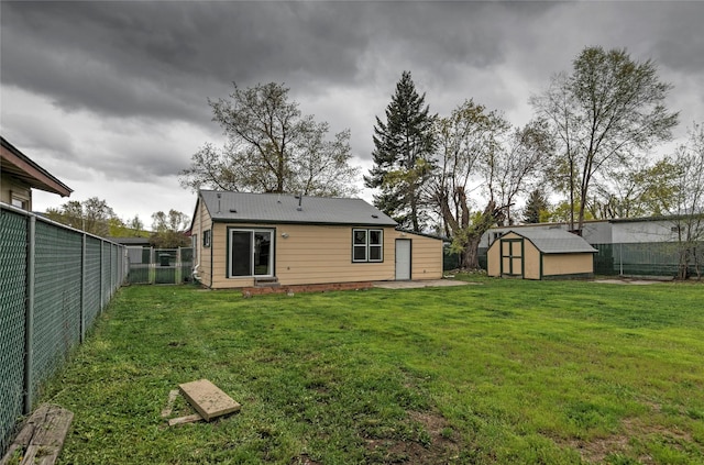 rear view of house featuring a patio, a fenced backyard, a storage unit, a lawn, and an outbuilding