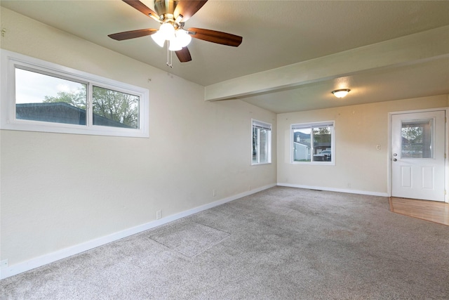 spare room with baseboards, ceiling fan, and carpet