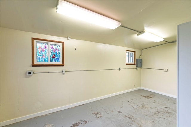 basement with baseboards and electric panel