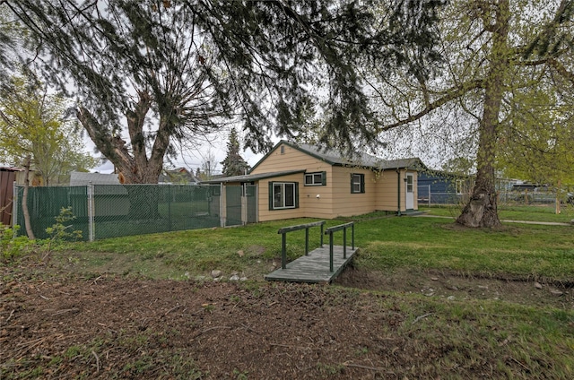back of house with a fenced backyard and a yard