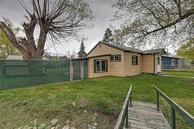 back of house with fence and a lawn