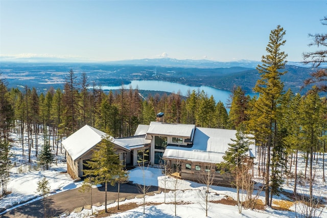 snowy aerial view with a forest view and a mountain view