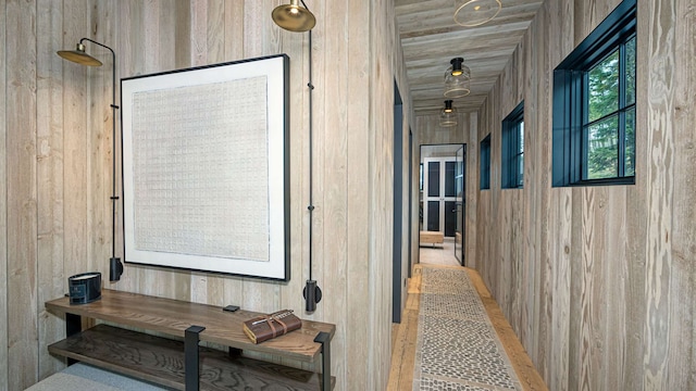 hallway featuring wooden walls