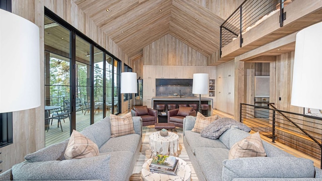 living room with high vaulted ceiling, wood walls, and wood finished floors