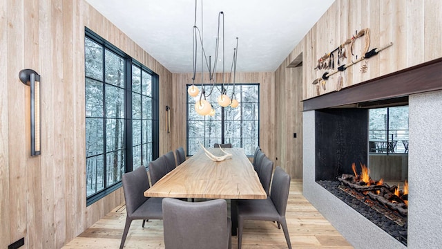 dining room with light wood finished floors and a lit fireplace