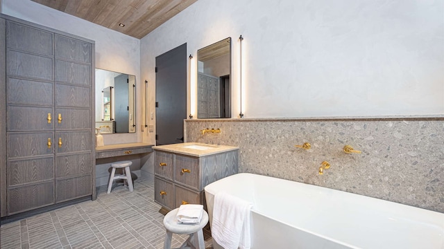 full bathroom featuring a freestanding tub, tile patterned flooring, wooden ceiling, a wainscoted wall, and vanity