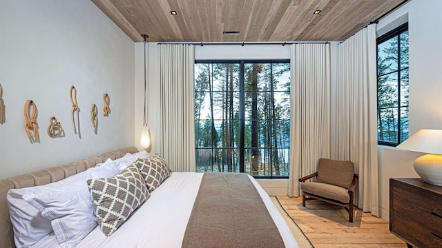 bedroom featuring wooden ceiling, multiple windows, and wood finished floors