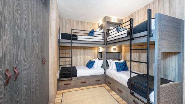 bedroom featuring wood finished floors and wooden walls