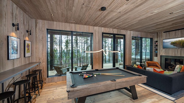 game room featuring wooden walls, wooden ceiling, and hardwood / wood-style flooring