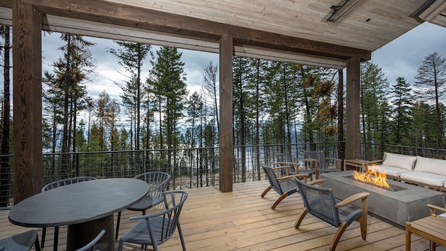wooden terrace featuring an outdoor living space with a fire pit