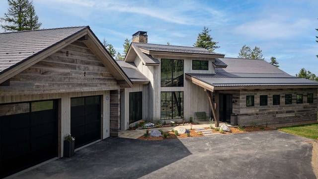 view of front of house with a garage, driveway, and a chimney