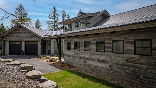 view of home's exterior with aphalt driveway and a garage