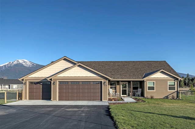 ranch-style home with a front lawn, aphalt driveway, fence, covered porch, and an attached garage