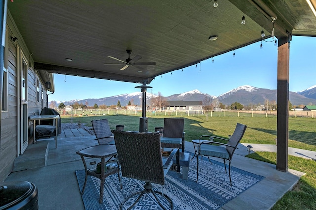 view of patio / terrace with ceiling fan, a mountain view, and outdoor dining space
