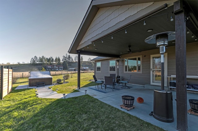 view of patio / terrace with a fenced backyard, ceiling fan, and a hot tub