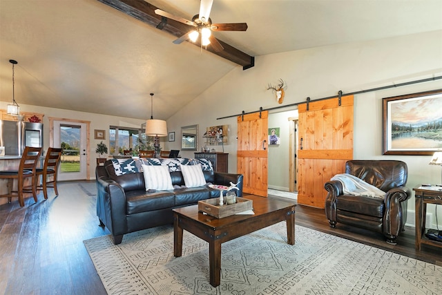 living area with lofted ceiling with beams, a ceiling fan, a barn door, and wood finished floors