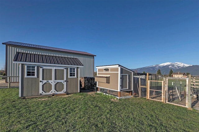 view of shed with exterior structure, fence, and a mountain view