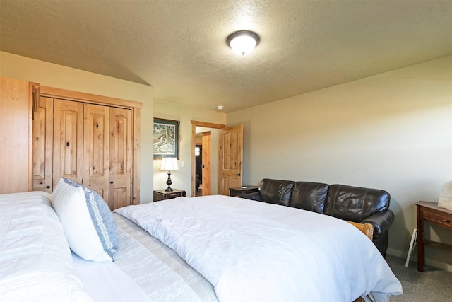 bedroom with baseboards, carpet, and a textured ceiling