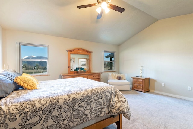 bedroom with baseboards, light colored carpet, multiple windows, and vaulted ceiling