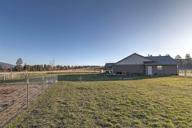 view of yard with fence and a rural view