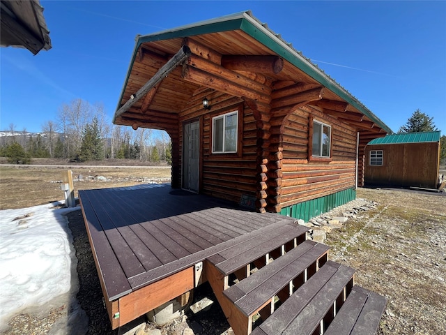 557 Crows Nest Main St, Haugan, MT 59842 - view of property exterior featuring a deck, an outbuilding, and log exterior