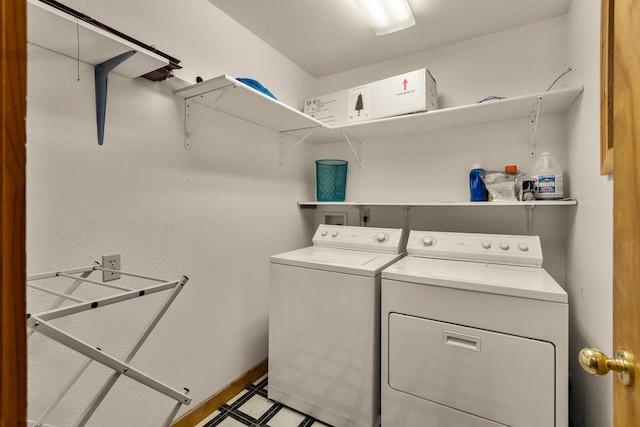washroom with washing machine and clothes dryer, laundry area, and baseboards