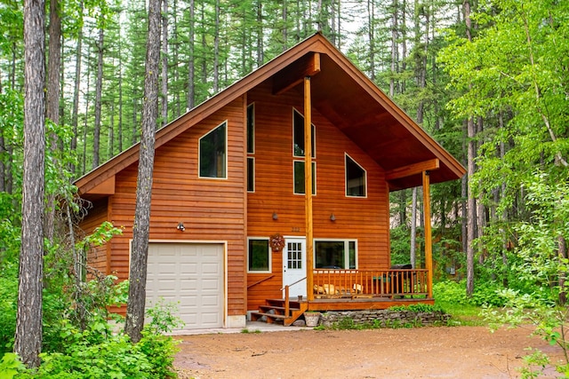 view of front of home with an attached garage, a deck, and aphalt driveway