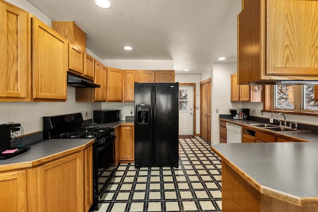 kitchen featuring a sink, recessed lighting, light floors, under cabinet range hood, and black appliances