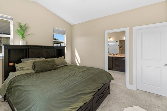 bedroom featuring connected bathroom, baseboards, light colored carpet, and lofted ceiling